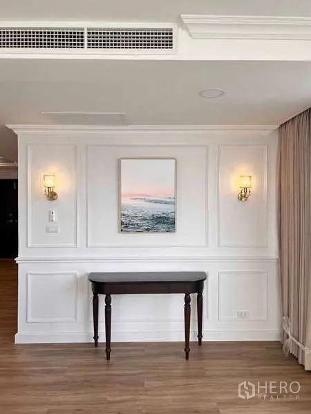 Condominium for rent or sale in Khlong Toei, Bangkok - Feature wall with classic paneling, side table and soft lighting