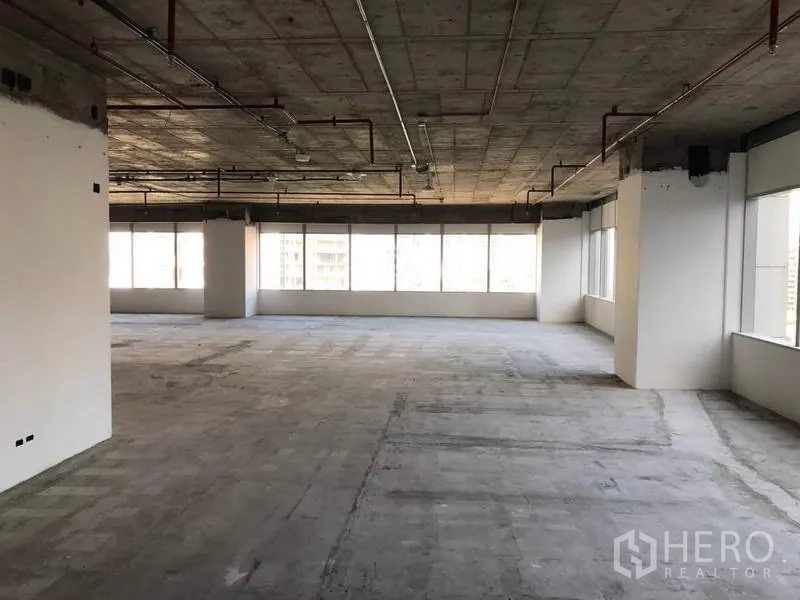 办公空间 出租在Bang Na, Bangkok - 毛坯工作区，周边玻璃与多根结构柱。