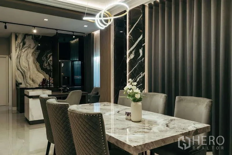 Detached House for sale in Sai Mai, Bangkok - Dining area with marble table, quilted chairs and contemporary pendant lighting.
