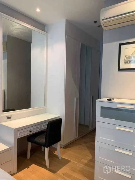 Condominium for sale in Watthana, Bangkok - Bedroom corner with built-in vanity, wardrobes and air-conditioning for ample storage and comfort.