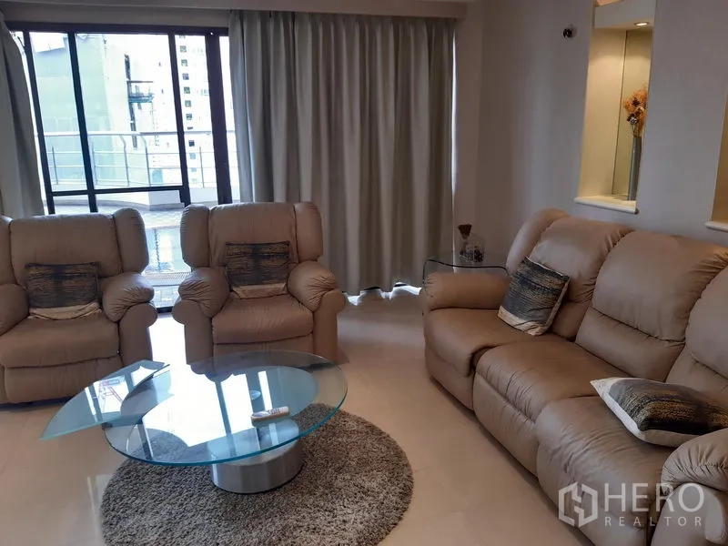 Condominium for rent in Khlong Toei, Bangkok - Cozy lounge area with three recliner sofas, floor-to-ceiling curtains and sliding doors to the terrace.