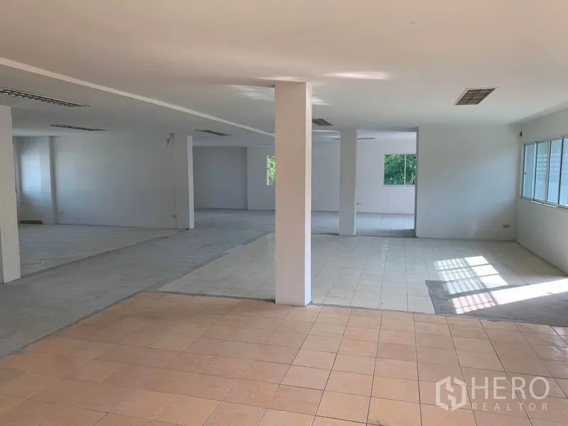Office Space for rent in Huai Khwang, Bangkok - Open office area with mixed tile zones, multiple windows and central support columns.