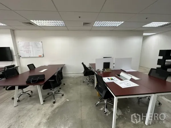 Office Space for rent in Khlong Toei, Bangkok - Shared workspace with meeting tables, swivel chairs and a wall whiteboard.