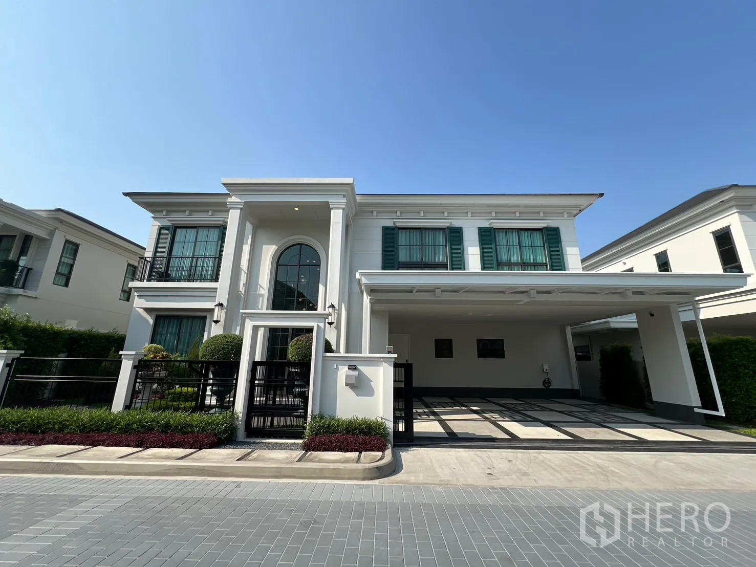 独栋房屋 for rent in Bang Phli, Samut Prakan - 两层白色独栋别墅，绿色百叶窗与前院围栏。