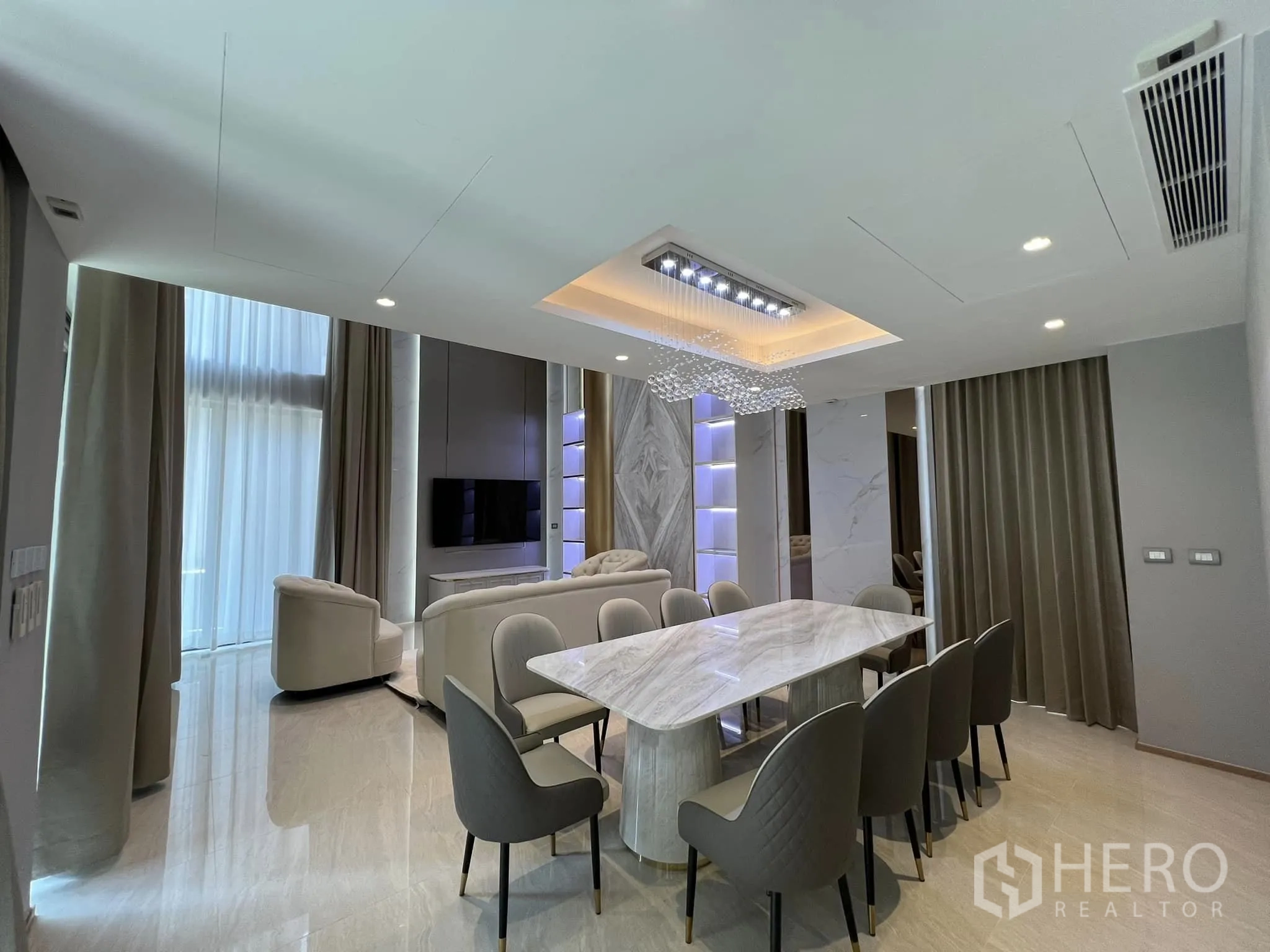 Detached House for rent or sale in Yan Nawa, Bangkok - Elegant dining and living area with a marble table and feature ceiling lights.