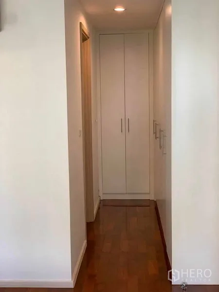 Condominium for rent or sale in Khlong Toei, Bangkok - Hallway with built-in closet and wooden flooring.