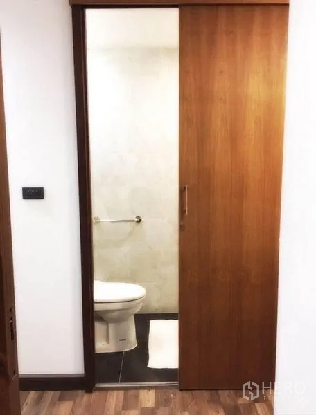 联排别墅 出租在Bang Rak, Bangkok - 通过木质推拉门可见的精致卫生间，风格简约。