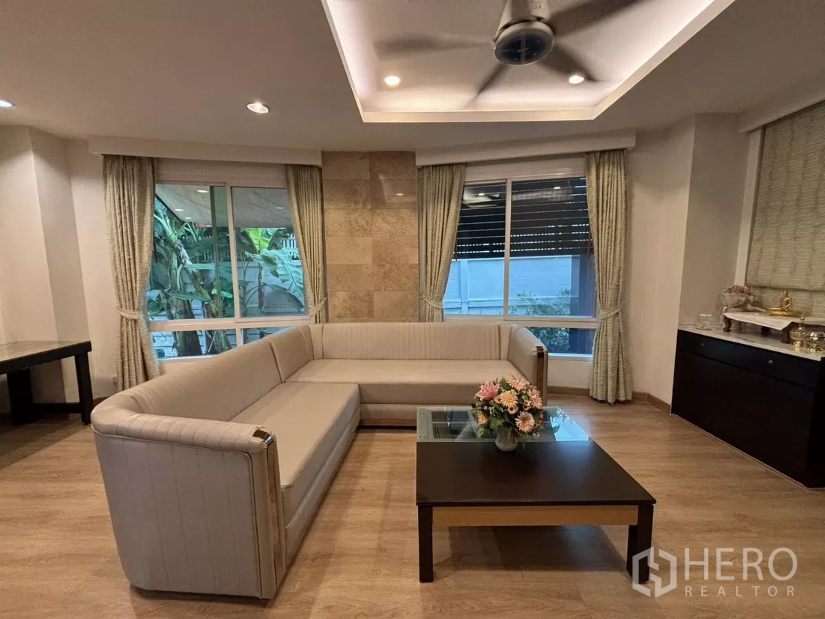 独立式住宅 出租在Bang Kapi, Bangkok - 舒适起居区，转角沙发与花园景窗。