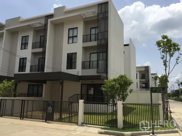 Townhouse for rent or sale in Saphan Sung, Bangkok - Three-storey modern townhouse exterior with gated front lawn and carport in Saphan Sung, Bangkok.
