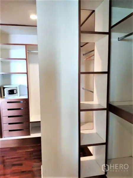 Condominium for rent in Bang Rak, Bangkok - Walk-in closet featuring built-in shelves, drawers and a personal safe.