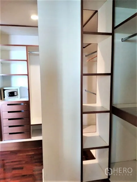Condominium for rent in Bang Rak, Bangkok - Walk-in closet featuring built-in shelves, drawers and a personal safe.
