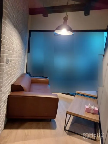 Office Space for rent in Chatuchak, Bangkok - Small lounge with brown sofa, coffee table and frosted glass partition.