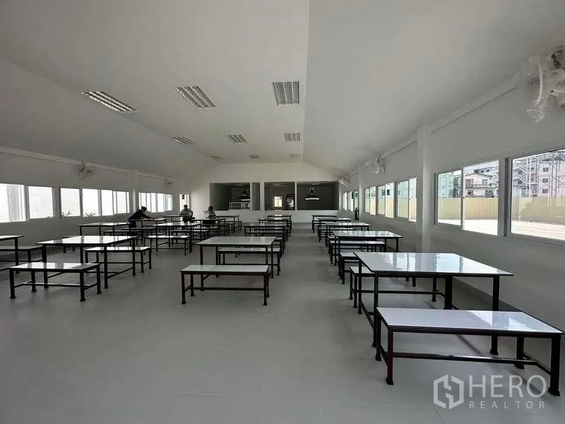Factory for rent in Khlong Luang, Pathum Thani - Staff canteen with rows of tables, bright windows and a serving counter.