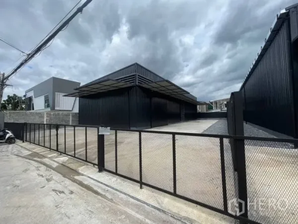 货栈 出租在Lat Phrao, Bangkok - 带大门的仓库入口和宽阔混凝土前院，配有宽大装卸雨棚。