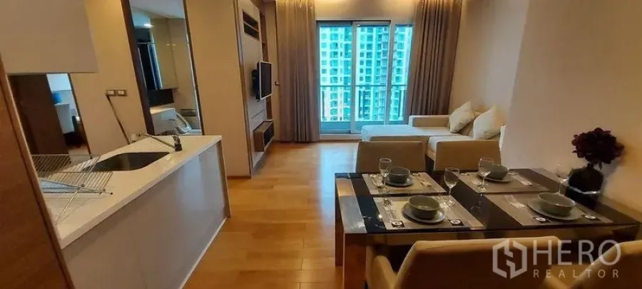 คอนโด ให้เช่าในRatchathewi, Bangkok - ครัวสมัยใหม่เชื่อมโต๊ะทานข้าวและห้องนั่งเล่น เปิดสู่ระเบียงวิวเมือง