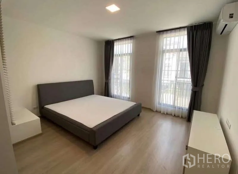 Townhouse for rent in Bang Phli, Samut Prakan - Spacious master bedroom with two tall windows, sheer drapes and air conditioning.