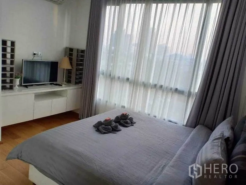 คอนโด ให้เช่าในWatthana, Bangkok - ห้องนอนมีหน้าต่างมุมขนาดใหญ่ ชั้นวางทีวี และชุดผ้าปูสีเทา