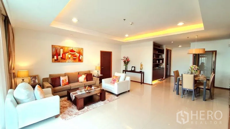 Apartment for rent in Khlong Toei, Bangkok - Wide-angle view of living and dining spaces with recessed lighting and tiled floors.