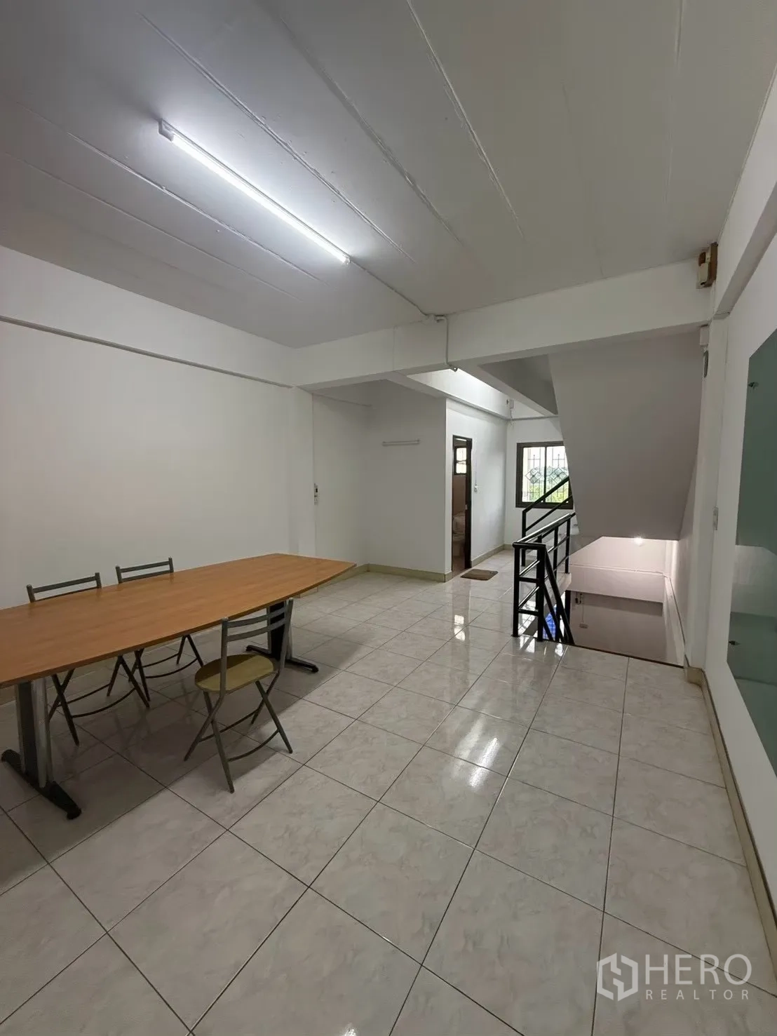 Shophouse for rent in Pak Kret, Nonthaburi - Open office area with tiled floor, table, and chairs.