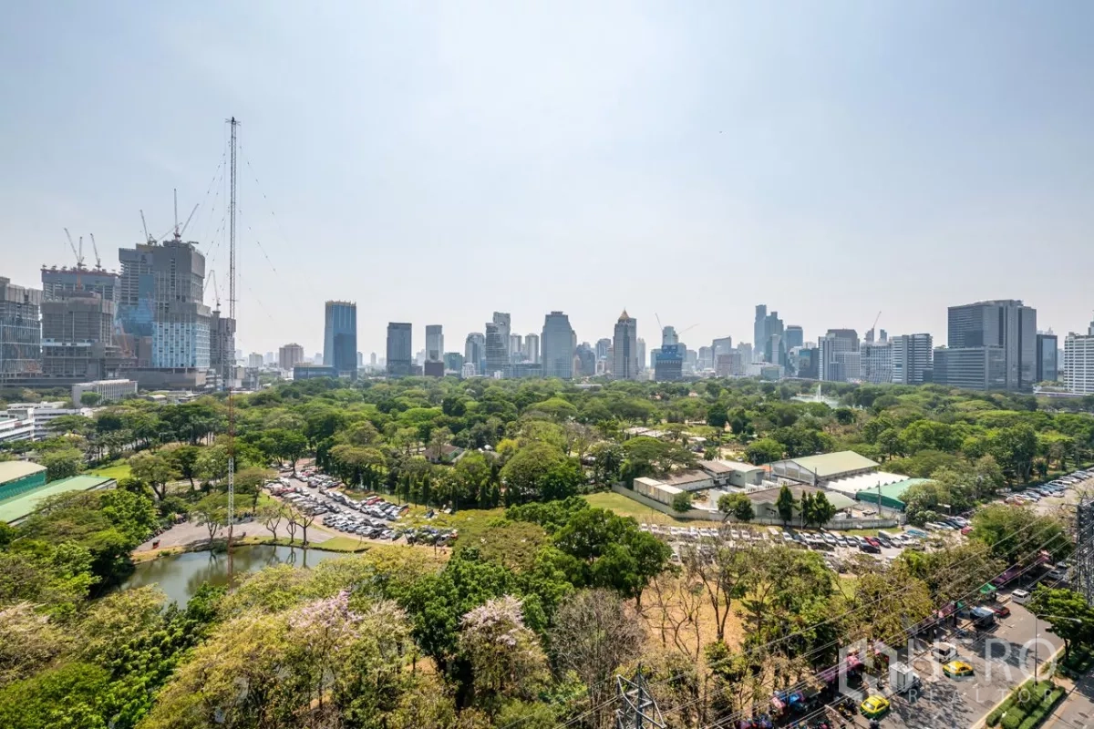 公寓 出租或出售在Pathum Wan, Bangkok - 俯瞰大片绿地与曼谷城市天际线的全景。
