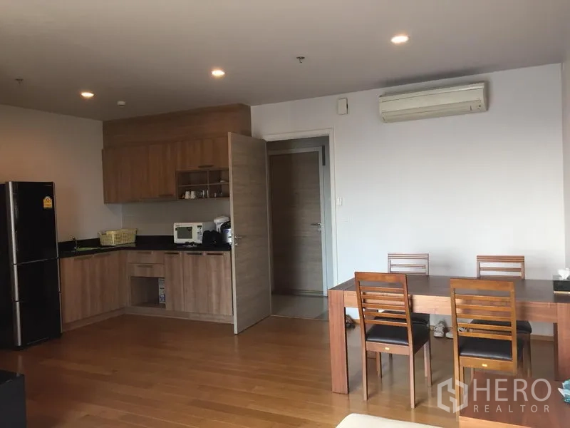 公寓 出租在Khlong San, Bangkok - 餐区位于开放式厨房旁，木桌四椅与空调。