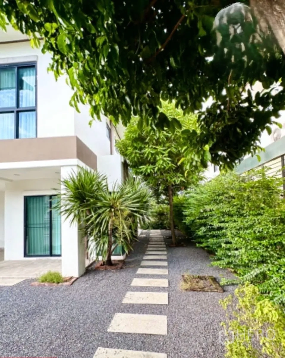 Detached House for sale in Lam Luk Ka, Pathum Thani - Landscaped side garden with stepping-stone path, trees and hedges next to the house.