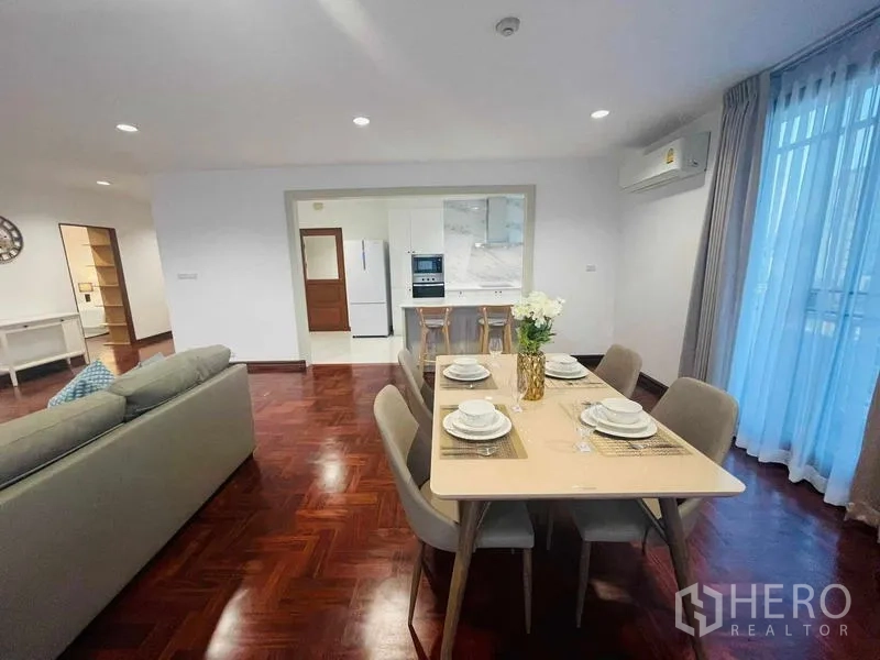 Condominium for rent - Open-plan dining and living area with parquet floors facing a bright kitchen.