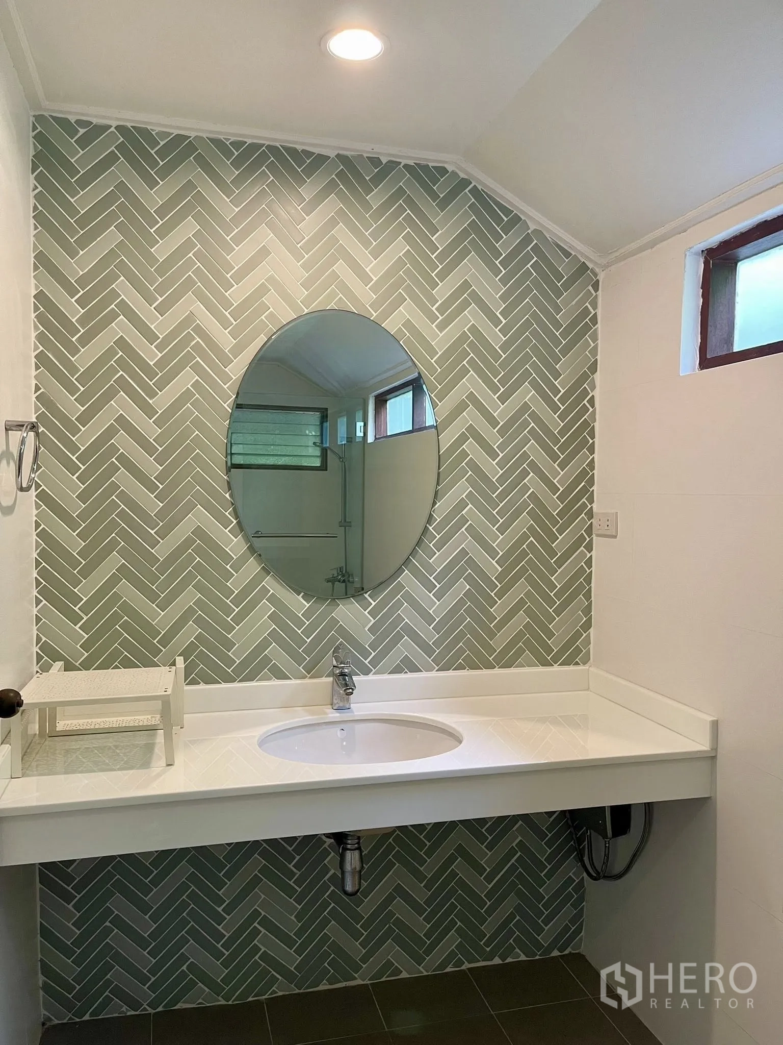 Detached House for rent in Pathum Wan, Bangkok - Bathroom featuring an oval mirror and green herringbone accent tiles.