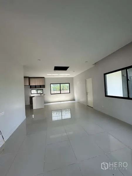 Detached House for sale in Lam Luk Ka, Pathum Thani - Spacious living-dining area with neutral decor and multiple windows.