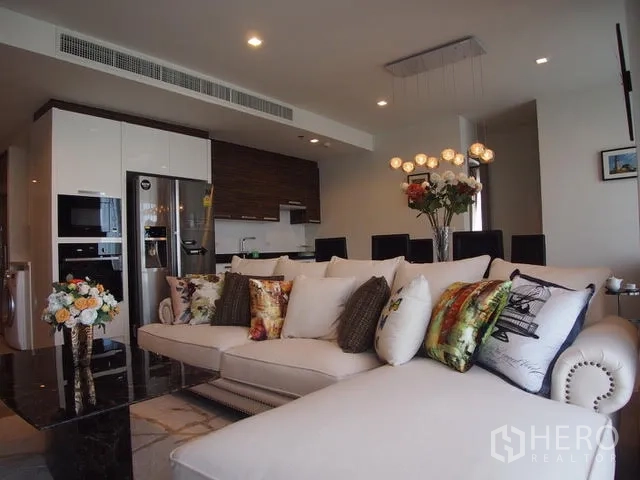 公寓 出售在Watthana, Bangkok - 开放式起居空间，转角沙发、吊灯，相连厨房与餐区，瓦他那公寓。