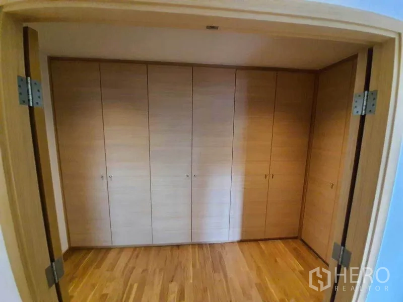 Condominium for rent or sale in Sathon, Bangkok - Wall of built-in floor-to-ceiling wooden wardrobes providing ample storage space.