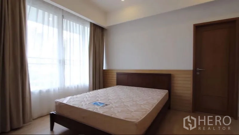 公寓 出租在Watthana, Bangkok - 温馨次卧配双人床与大窗帘，光线柔和。