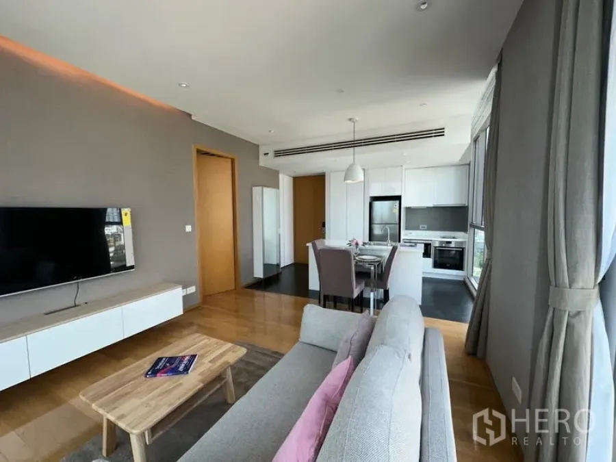 公寓 出租在Watthana, Bangkok - 起居、餐厅与L形厨房一体化，吊灯与全景窗户提升采光。