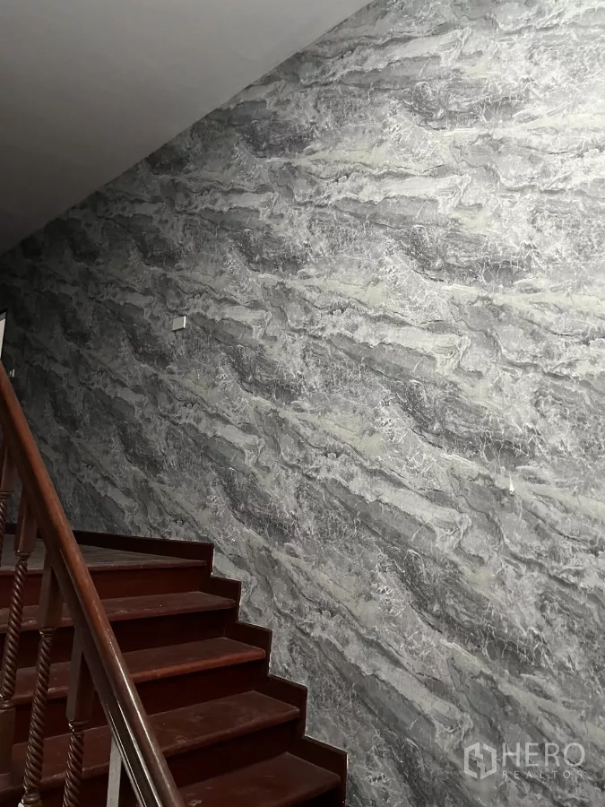 Detached House for rent in Watthana, Bangkok - Interior staircase with polished wooden steps and a grey marble-pattern wall.