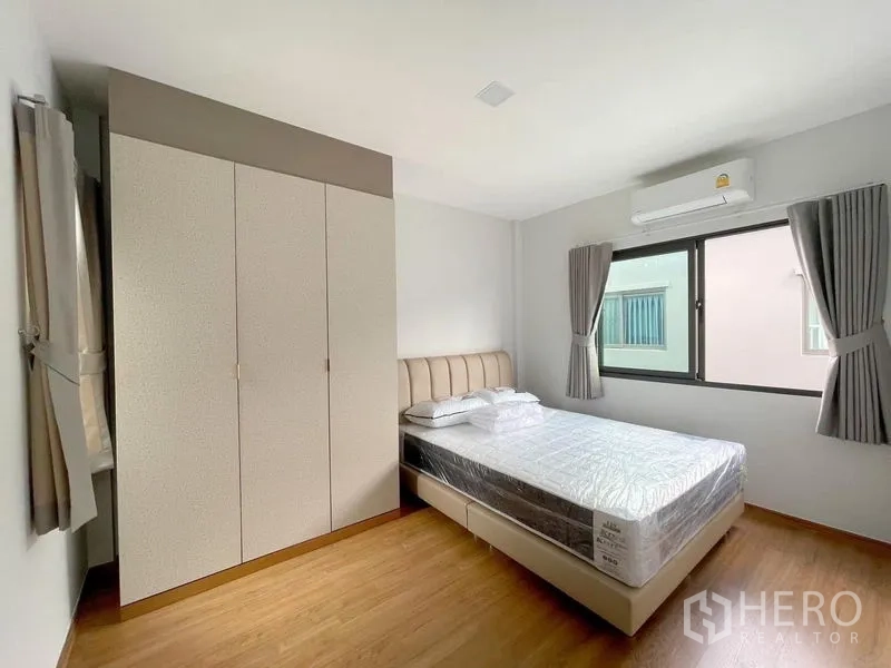 联排别墅 出租在Bang Phli, Samut Prakan - 次卧配双人床、衣柜、空调与两面窗户。