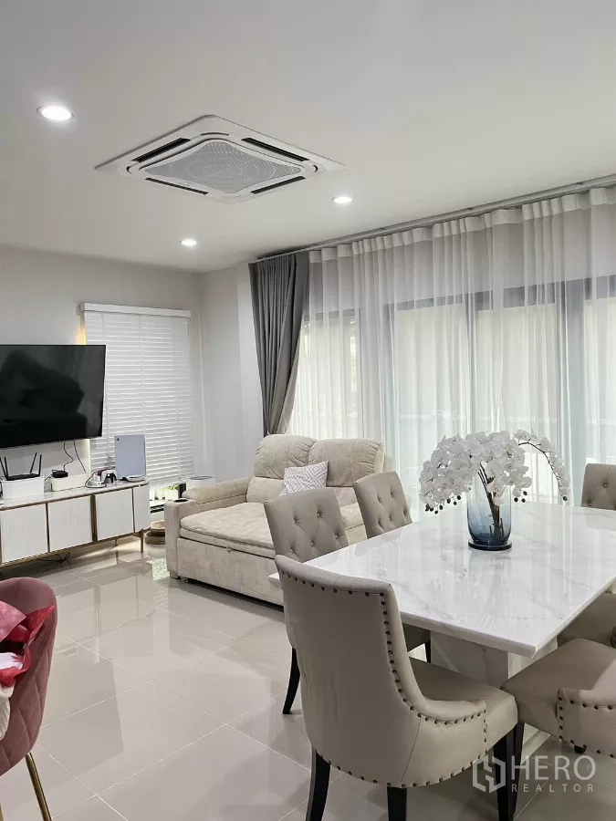 Detached House for rent in Saphan Sung, Bangkok - Bright open-plan living and dining area with marble-top table, sofa, TV console and ceiling cassette air conditioner.