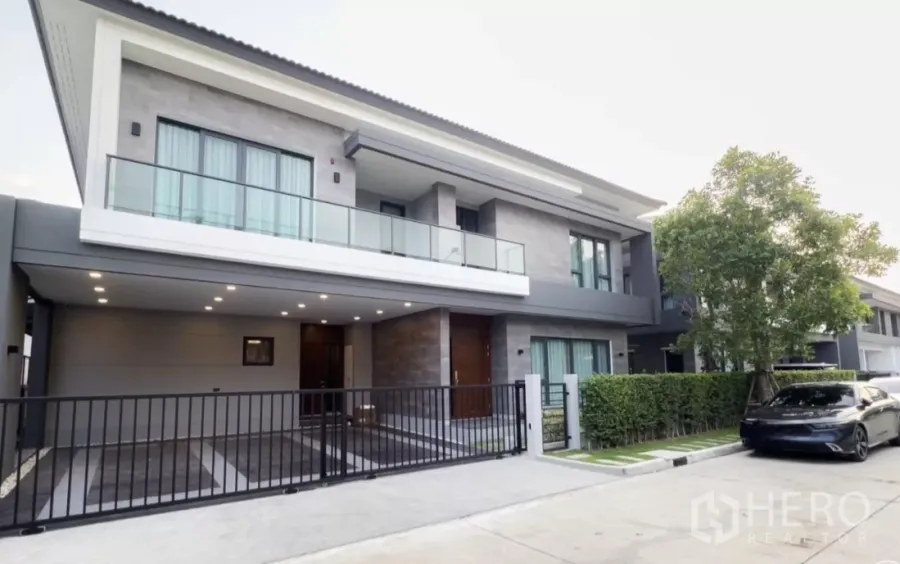独立式住宅 出租在Bang Phli, Samut Prakan - 现代两层独栋外观，玻璃阳台、入户庭院与带门车位