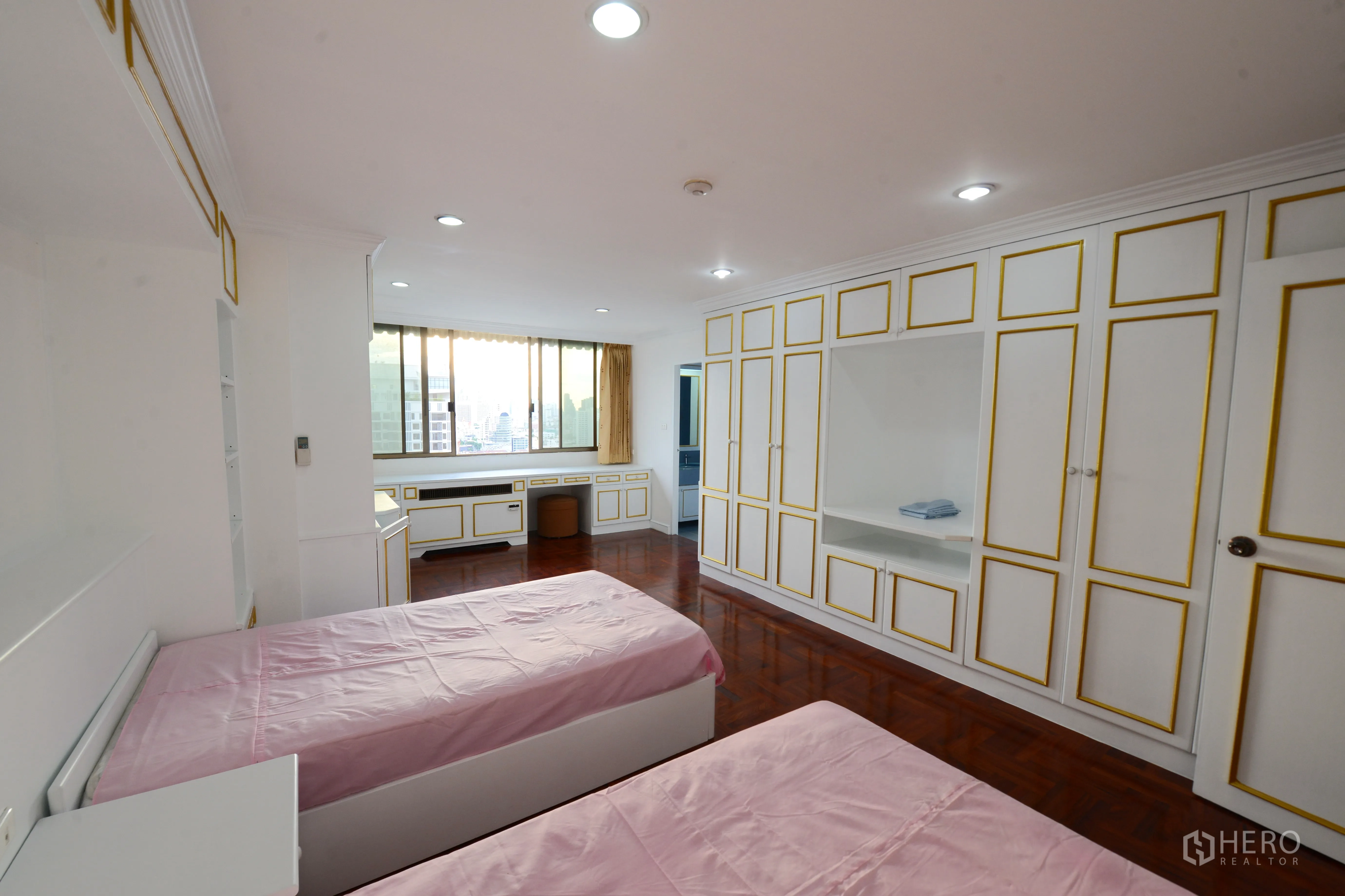 Condominium for rent or sale in Watthana, Bangkok - Twin bedroom with built-in wardrobes, city-view window and polished wood floors