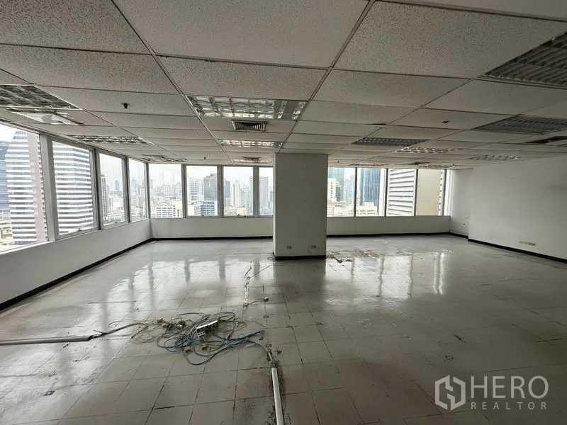 办公空间 出租在Chatuchak, Bangkok - 无家具的办公室内景，地面走线与环绕大窗