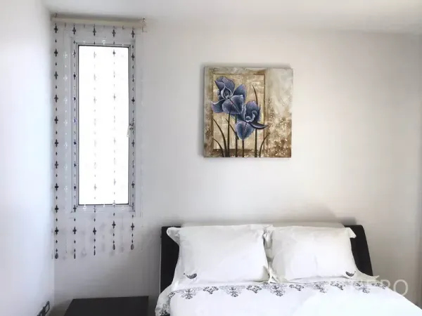公寓 出租在Watthana, Bangkok - 明亮卧室，白色床品，窄窗配串珠窗帘，床头悬挂花卉装饰画。