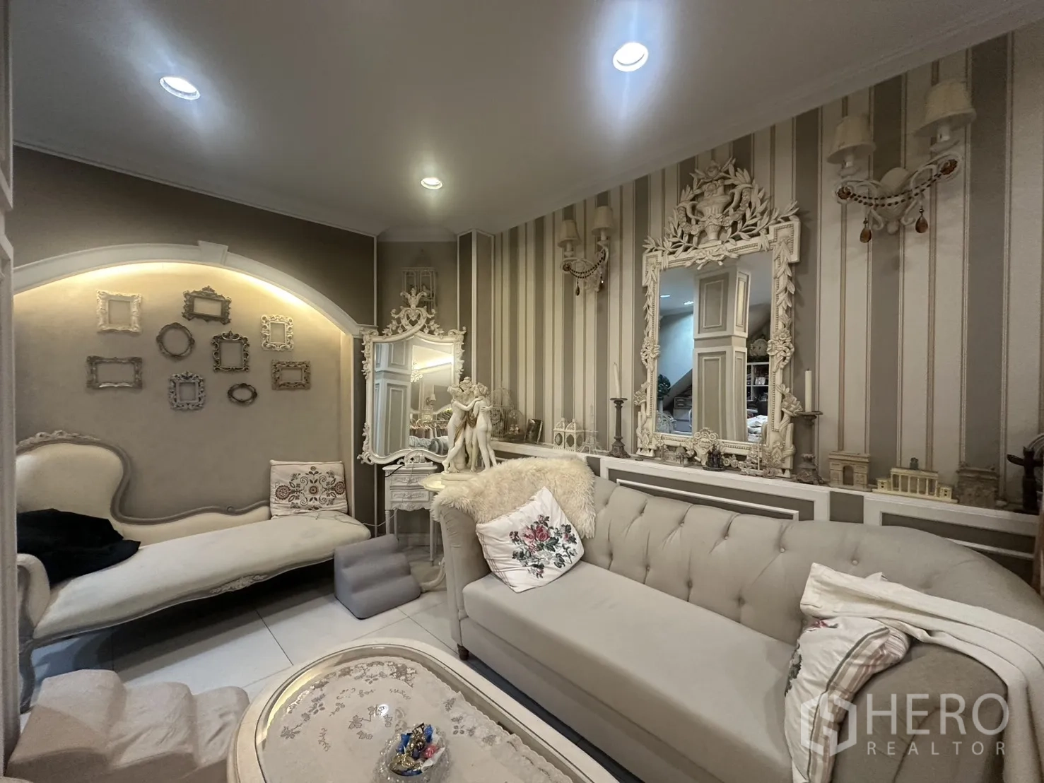 ตึกแถว for sale in Watthana, Bangkok - ห้องนั่งเล่นสไตล์คลาสสิกมีโซฟาทัฟต์ กระจกตกแต่ง และไฟส่องผนัง.