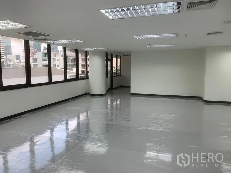 Office Space for rent in Bang Rak, Bangkok - Section of the office showing window line, suspended ceiling lights and skyline outlook.