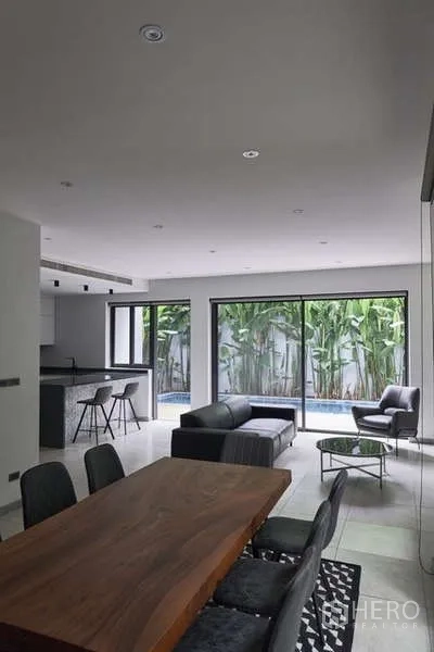 Townhouse for sale in Watthana, Bangkok - Living–dining space with sliding glass doors to a courtyard garden and plunge pool.