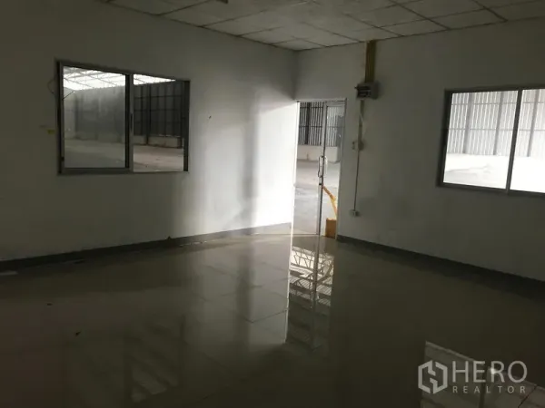 Warehouse for rent in Mueang Samut Prakan, Samut Prakan - Ground‑floor office inside the warehouse with tiled floor, windows and a glass door.