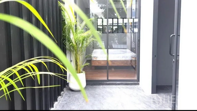 带办公室的家 出租或出售在Khlong Toei, Bangkok - 灰色瓷砖小庭院，推拉玻璃门通向卧室，周围有棕榈盆栽。