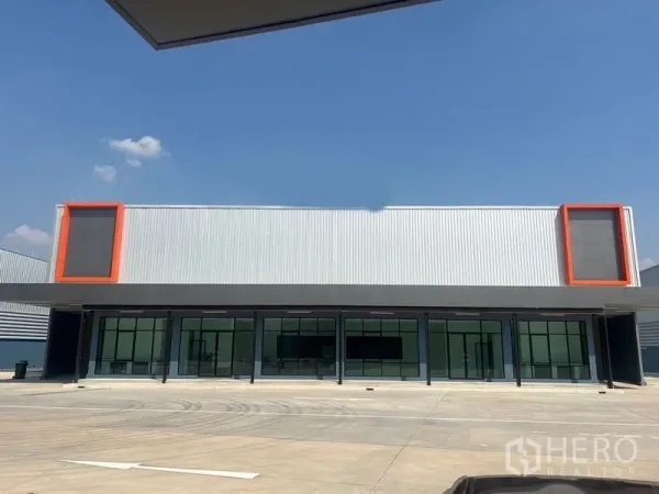คลังสินค้า ให้เช่าในBang Phli, Samut Prakan - ด้านหน้าโกดังสมัยใหม่ พร้อมสำนักงานกระจกและกรอบสีส้ม ใต้ท้องฟ้าโปร่ง