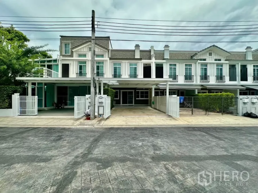 联排别墅 出租在Prawet, Bangkok - 北欧风联排外立面，白色墙面与小阳台的街景。