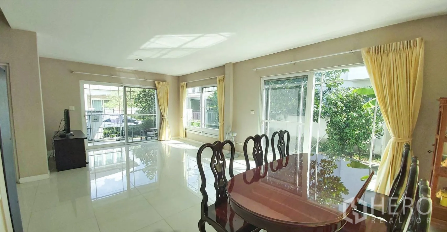 Detached House for sale in Bang Kapi, Bangkok - Open-plan living and dining area with large sliding glass doors and garden views.
