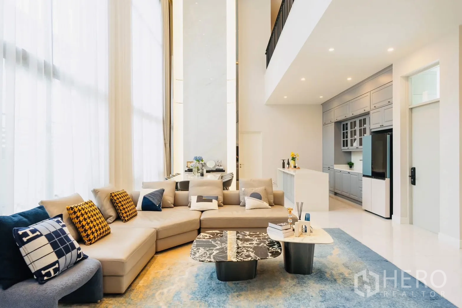 Detached House for rent or sale in Bang Kapi, Bangkok - Open-plan living with sectional sofa, marble coffee tables, and adjacent kitchen.