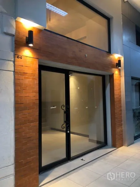 Retail Space for rent in Watthana, Bangkok - Illuminated glass storefront with brick cladding and a double-height window at a retail unit.